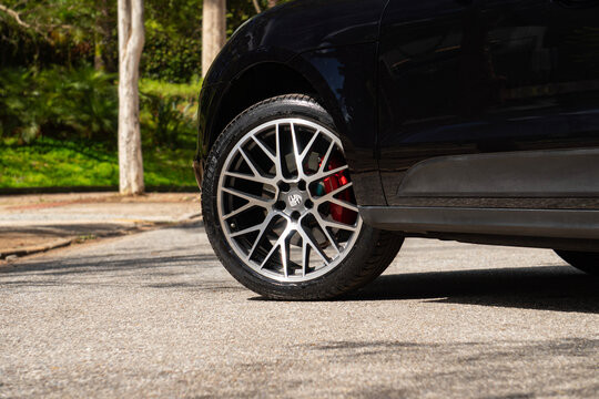 Black Porsche Macan front wheel close up, Luxury compact SUV parked outdoors