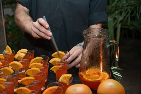 Manos preparando tragos en copas peque&ntilde;as 