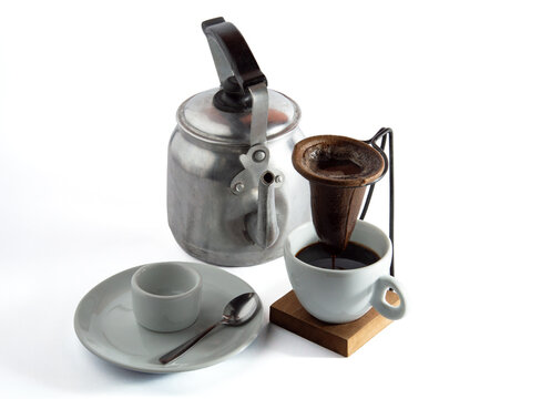 Top view of traditional Brazilian drip coffee set with cloth filter, aluminum kettle and coffee cups