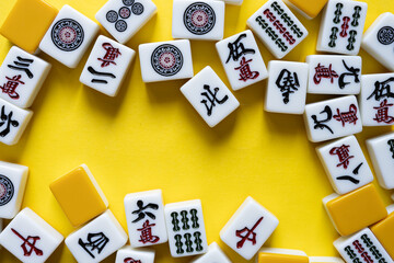 Fototapeta na wymiar 黄色背景に並ぶマージャン牌