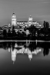 Obraz premium Salamanca, Castilla y Leon, Spain: Twilight view of the Cathedral of Salamanca illuminated and reflected in the waters of river Tormes; the Old Cathedral, Cathedral of Santa Maria in black and white
