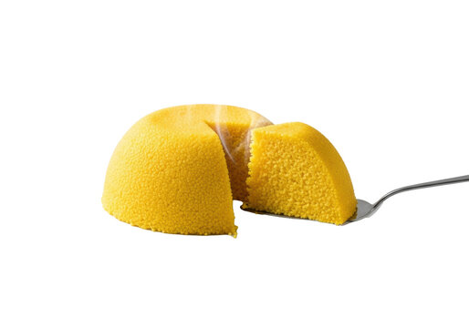 A vibrant yellow, dome-shaped Cuscuz Paulista, with a steaming slice removed, on a white plate with a silver utensil against a pristine studio background, concept of culinary excellence