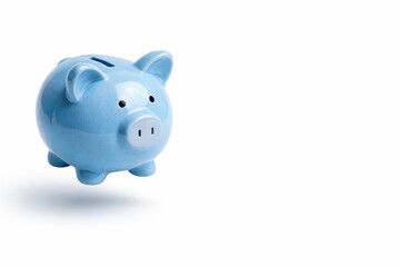 Studio photo of a blue ceramic piggy bank floating above a white background with soft shadow