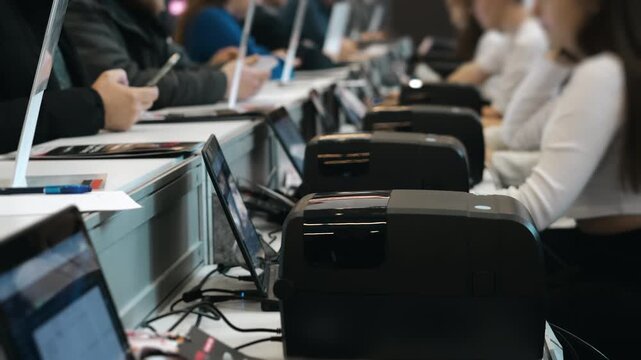 Conference registration desk where staff check in participants and print badges during corporate business event or professional seminar.