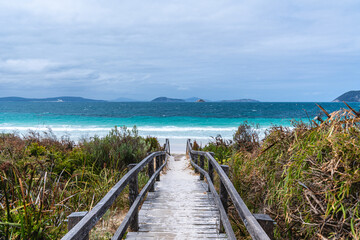 Obraz premium Wooden walkway leading to beautiful ocean beach
