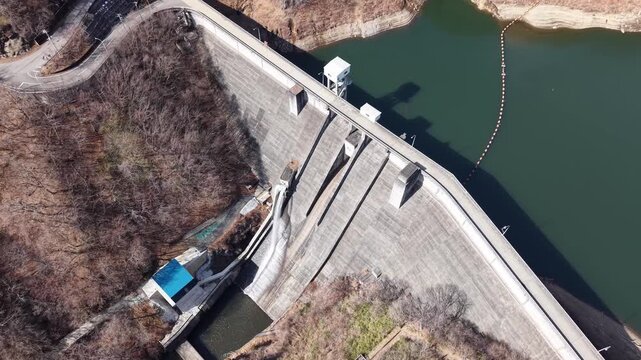 Top aerial view of Kirizumi Dam reservoir surrounded by forest, Japan