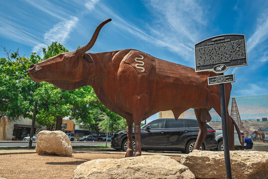 Statue Sculpture of Brown Texas Longhorn Cow With Descriptive Sign With Blue Sky in Odessa, Texas