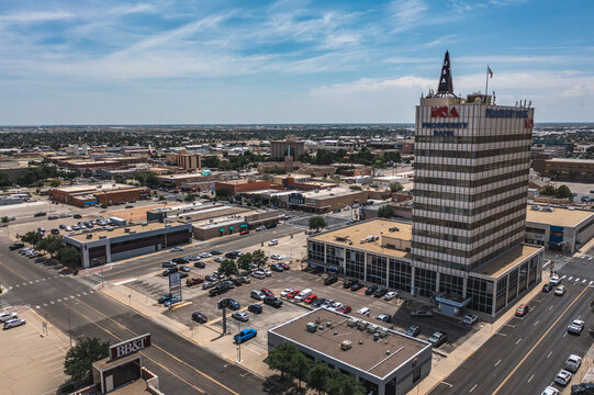 Aerial Drone View of Prosperity Bank Sign on Tall Commercial Office Building Surrounded By other Buildings With Blue Sky in Downtown Odessa, Texas