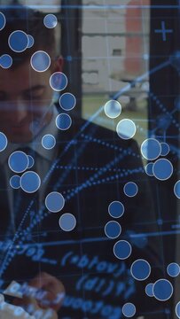 Businessman at window handling small device, checking data via shifting blue overlay obscuring face