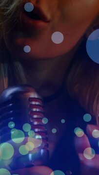 Vertical video: Female singer lifting vintage mic into frame, revealing lips and singing for power
