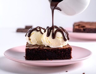 Chocolate sauce is drizzled over vanilla ice cream atop a brownie slice on a pink plate