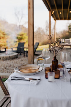 Table set for dinner on a patio at a getaway cabin.