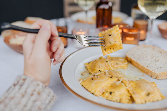 Butternut squash ravioli with brown butter sauce for dinner on a patio.