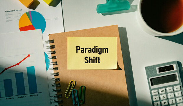Business concept of Paradigm Shift represented on sticky note with coffee, prop document with graphs drawn on it, calculator. Ideal for marketing and promotional content.