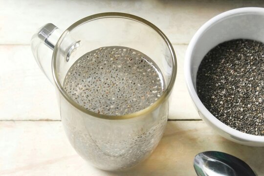 top view of a glass of chia seed water, on a wooden table