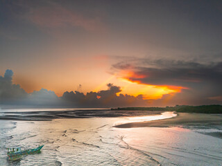 The beautiful colors at sunrise create a peaceful atmosphere, and the reflection of light on the river near the estuary adds to the vibrant morning ambiance © HeinrichDengi