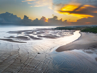 The beautiful colors at sunrise create a peaceful atmosphere, and the reflection of light on the river near the estuary adds to the vibrant morning ambiance © HeinrichDengi