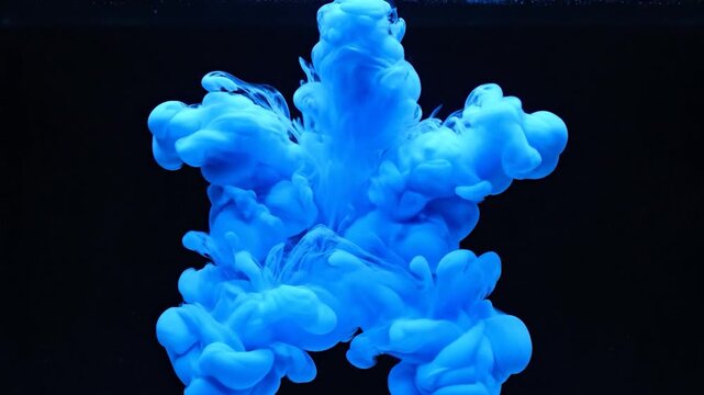 Vibrant blue ink dissolving gracefully in clear water creating an abstract cloud