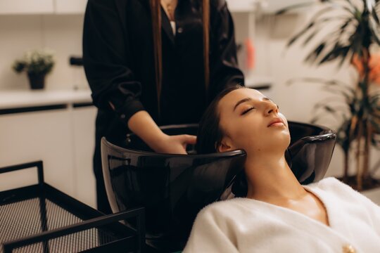 Woman enjoying hair washing service at salon