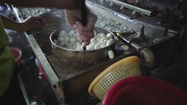 Traditional silk spinning machine processing silkworm cocoon thread in rural sericulture textile production