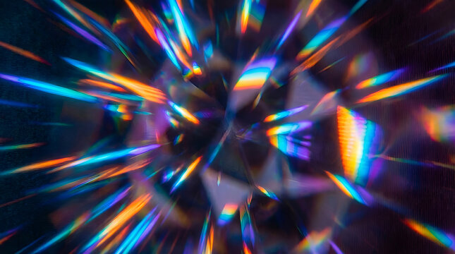 Abstract close-up of a faceted diamond or crystal reflecting vibrant rainbow light rays and colorful refractions, creating a dazzling optical effect and sparkling background.