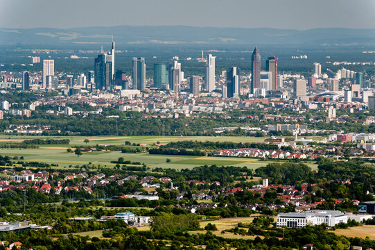 Skyline von Frankfurt am Main vom Taunus aus gesehen mit den Hochh&auml;usern der Innenstadt und H&auml;usern von Gemeinden und Siedlungen im Vordertaunus mit Feldern und W&auml;ldern