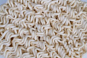 Abstract beige noodles forming rhythmic patterns. Monochrome beige composition of dry instant noodles arranged in rhythmic wave and loop patterns showcasing organic geometry