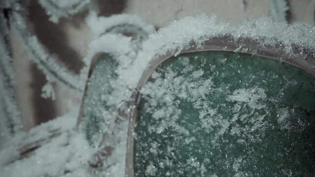 Frosted visor green lens closeup evidence, fine crystalline snow obscuring view, metal rim pocked with rust, close textured detail, monitoring gear for radiation survey, sterile field mood, fallout