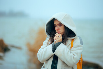 Person Blows into Hands from Cold Outside Freezing. Depressed person feeling cold outside being unhappy an uncomfortable    © nicoletaionescu