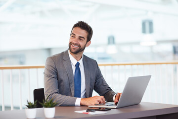 Fototapeta premium Businessman, laptop and happy with thinking at office with review, insight and typing at investment company. Person, broker and financial advisor with computer, perspective and report at agency
