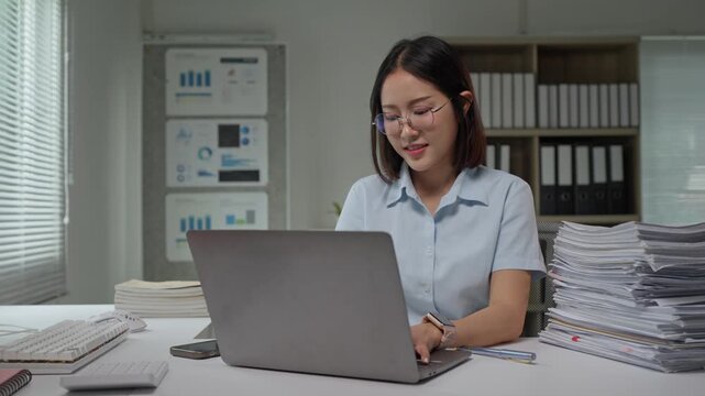 Asian businesswoman working hard on laptop in a modern office