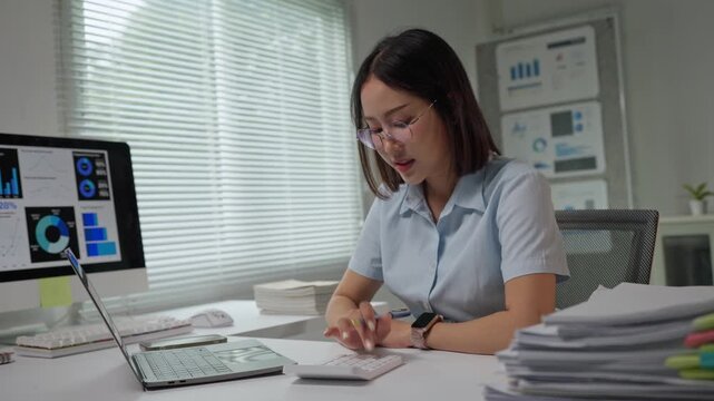 Asian accountant woman calculating business finances at her desk