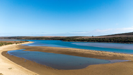 Scenic view of the Gourits River Estuary at Gouritsmond on the Western Cape coast of South Africa, where the winding river meets the Indian Ocean, creating a tranquil landscape of water and sandbanks.