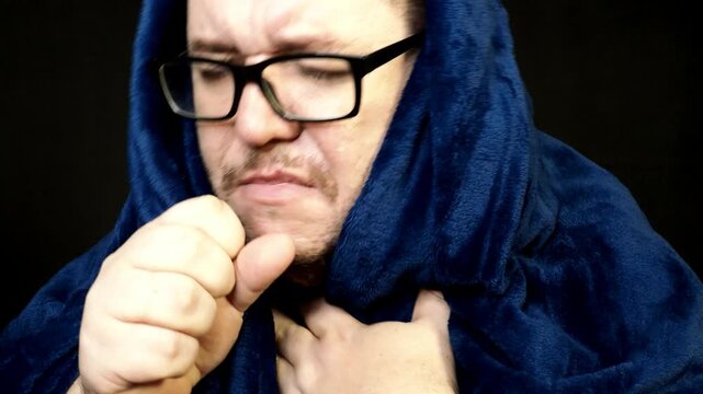 Young man with glasses wipes his nose with a white napkin. 