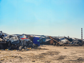 Fototapeta premium A scene of a demolished building with a truck and debris under a clear sky.