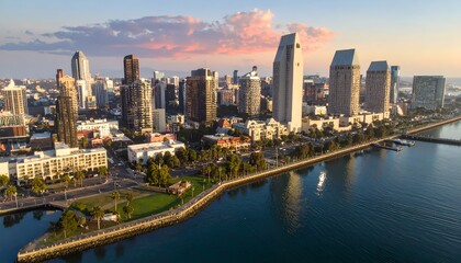 Obraz premium Modern city skyline with tall buildings along the waterfront at sunset