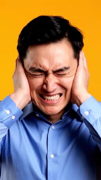 Man Grimacing Covering Ears Loud Noise
