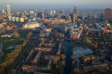 Obraz premium Aerial image of the Birmingham canal network and residential estates at dusk, featuring modern skyscrapers at Sunset. 