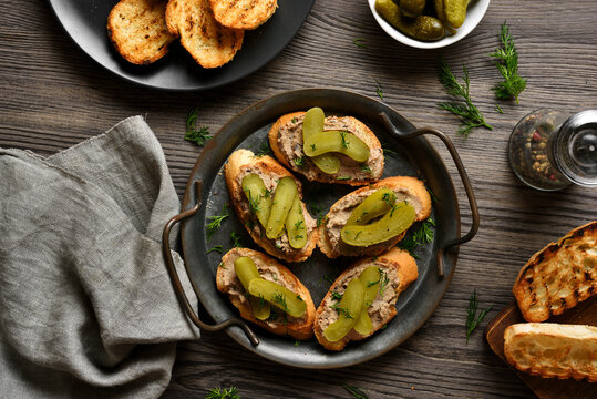 Open sandwiches with liver pate on wooden background