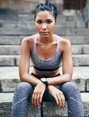 Fototapeta premium Portrait, athlete and woman on stairs, fitness and serious for health goals, confident and wellness. Outdoor, runner and person with pride on break, determination and rest after exercise in Brazil