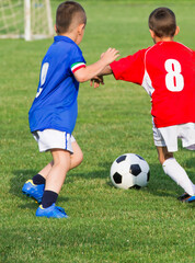 Fototapeta premium Boys kicking football on the sports field