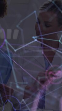 Vertical video: Doctor and nurse reviewing form for care, purple icons fading in causing notes