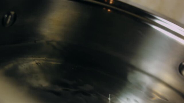 A teaspoon of salt is added to the pot of boiling water