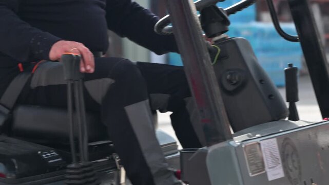 Forklift operator driving in reverse controlling warehouse industrial vehicle. High quality 4k footage