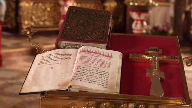 Open gospel book on church lectern inside Orthodox Christian church. Sacred scripture used during traditional worship and liturgy with golden interior in background.