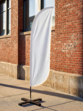 Blank white mockup bow flag standing brick wall sidewalk retail store supermarket outdoor commercial advertising banner template design shopping