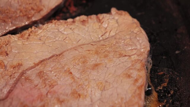The process of cooking beef chops in a frying pan at home.