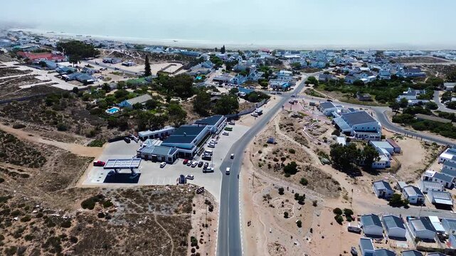 High POV Camera panning up along the road leading into Paternoster. Paternoster picturesque seaside tourist town with traditional white fishing cottages and houses. 4K Aerial Video.