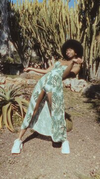 Stylish cuban woman dancing outdoors in a cactus garden
