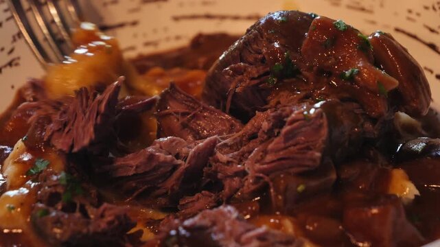 Beef chuck roast, a juicy and tender cut with mushrooms and with mashed potatoes herbs oven-baked.